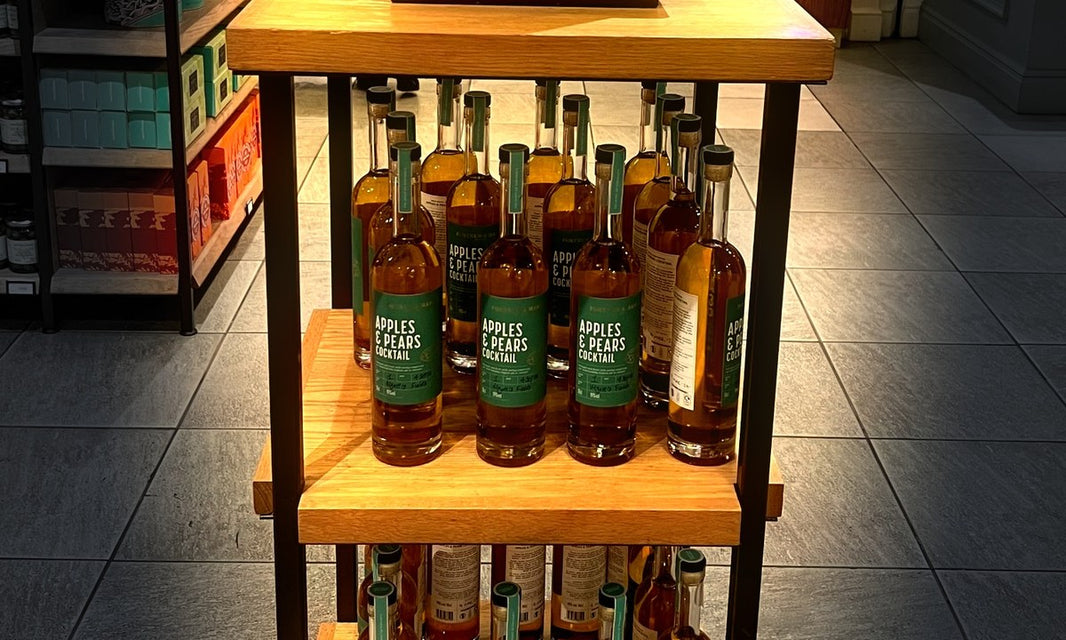 Bottles of Apples & Pears Cocktail on a wooden stand at Fortnum & Mason, Piccadilly