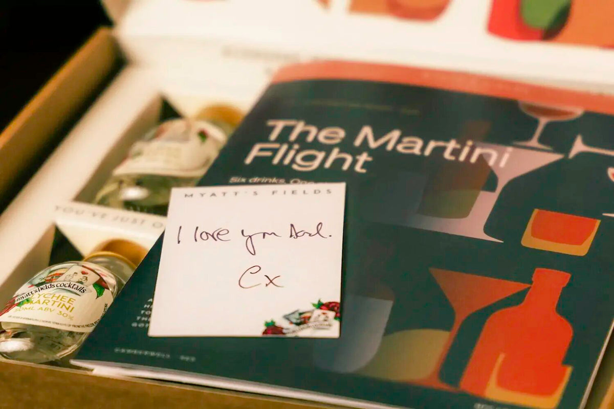 The Martini Flight box open: six 50ml Martinis, the illustrated brochure and a handwritten gift card